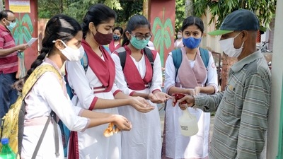 Students sanitize their hands before entering their school premise in Nadia, West Bengal. (PTI) Students sanitize their hands before entering their school premise in Nadia, West Bengal. (PTI)