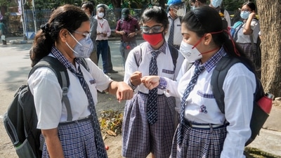 Students maintain social distancing and greet each other with fist bumps as they arrive at a school to attend class after after 20 months in West Bengal. (PTI) Students maintain social distancing and greet each other with fist bumps as they arrive at a school to attend class after after 20 months in West Bengal. (PTI)
