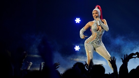 Rapper Saweetie performs on stage wearing a shimmery blue body hugging corset ensemble.(REUTERS)