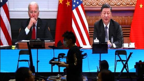 A screen shows US President Joe Biden (left) and Chinese President Xi Jinping attending a virtual meeting on Tuesday. (REUTERS)