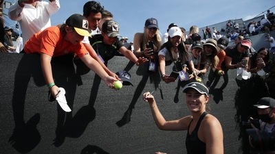 Spain's Garbine Muguruza signs autographs for fans after winning her semi final match against Spain's Paula Badosa&nbsp; (REUTERS)