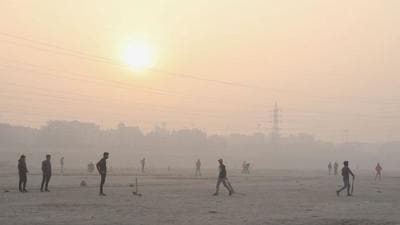 People play cricket on the floodplains of the Yamuna river on a smoggy morning in New Delhi, India on Wednesday. (REUTERS) People play cricket on the floodplains of the Yamuna river on a smoggy morning in New Delhi, India on Wednesday. (REUTERS)