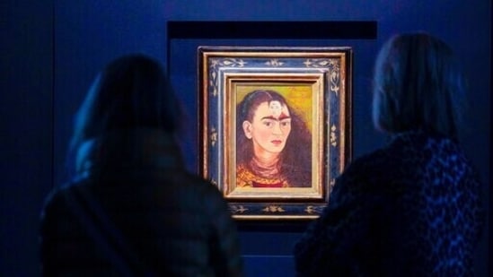 Visitors inspect Frida Kahlo's "Diego y yo" on display at Sotheby's auction house.(AP)