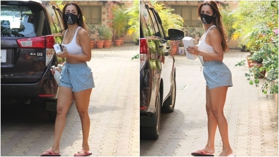 Malaika teamed the top with mini shorts in a light blue shade. She styled the outfit with flip flops, a printed black face mask to stay safe amid the pandemic, and centre-parted open tresses.(HT Photo/Varinder Chawla)