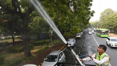 New Delhi, India - Nov. 18, 2021: A New Delhi Municipal council (NDMC ) Horticulture department worker sprays water on trees to control pollution on Rafi Marg near Parliament house in New Delhi, India, on Thursday, November 18, 2021. (Photo by Arvind Yadav/ Hindustan Times) (Arvind Yadav/HT PHOTO) New Delhi, India - Nov. 18, 2021: A New Delhi Municipal council (NDMC ) Horticulture department worker sprays water on trees to control pollution on Rafi Marg near Parliament house in New Delhi, India, on Thursday, November 18, 2021. (Photo by Arvind Yadav/ Hindustan Times) (Arvind Yadav/HT PHOTO)