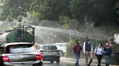 New Delhi, India - Nov. 18, 2021: A New Delhi Municipal council (NDMC ) Horticulture department worker sprays water on trees to control pollution on Rafi Marg near Parliament house in New Delhi, India, on Thursday, November 18, 2021. (Photo by Arvind Yadav/ Hindustan Times) (Arvind Yadav/HT PHOTO)