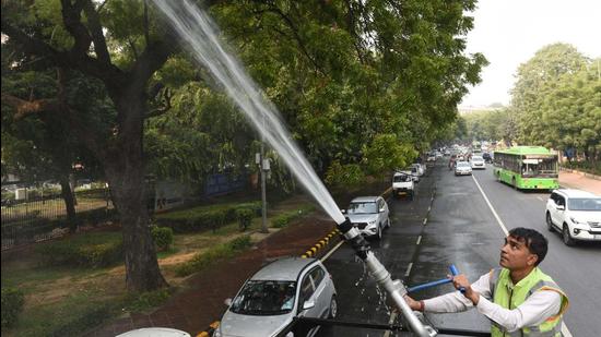 New Delhi, India - Nov. 18, 2021: A New Delhi Municipal council (NDMC ) Horticulture department worker sprays water on trees to control pollution on Rafi Marg near Parliament house in New Delhi, India, on Thursday, November 18, 2021. (Photo by Arvind Yadav/ Hindustan Times) (Arvind Yadav/HT PHOTO)