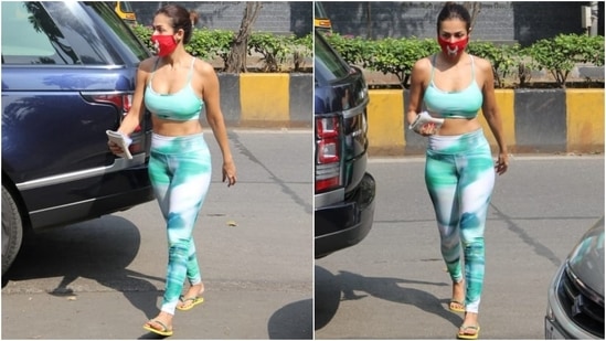 The workout look included a spaghetti-strapped sports bra with a scooped neckline and a cropped length that flaunted Malaika's washboard abs. She wore it with matching high waist fitted tights.(HT Photo/Varinder Chawla)