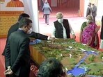 Prime Minister Modi inspecting the models of various developmental projects that are to be inaugurated in Mahoba. (Photo via ANI)