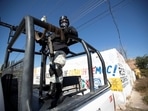 A member of the National Guard at a crime scene where assailants left 10 bodies of men hanging from a bridge in Mexico.