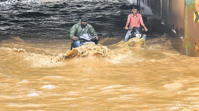 Commuters wade through a waterlogged underpass at Kodigehalli in Bengaluru on Friday. (PTI) Commuters wade through a waterlogged underpass at Kodigehalli in Bengaluru on Friday. (PTI)