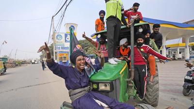 Farmers celebrate news of the repeal of the three farm laws, in Singhu on the outskirts of New Delhi on Friday. (AP) Farmers celebrate news of the repeal of the three farm laws, in Singhu on the outskirts of New Delhi on Friday. (AP)
