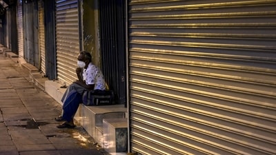 A man sits in front of closed shops on a deserted street in Colombo (AFP) A man sits in front of closed shops on a deserted street in Colombo (AFP)