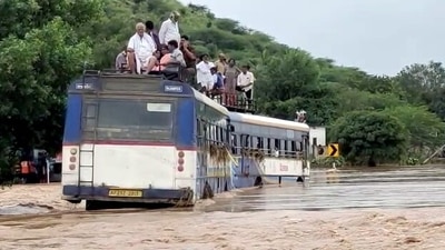 People traveling on the roof of a partially submerged underwater bus following heavy rainfall in Kadapa. (ANI) People traveling on the roof of a partially submerged underwater bus following heavy rainfall in Kadapa. (ANI)