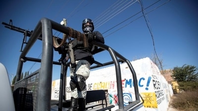 A member of the National Guard at a crime scene where assailants left 10 bodies of men hanging from a bridge in Mexico. (Reuters)