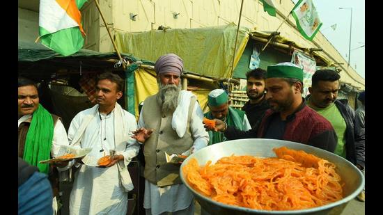 Farmers distributing sweets at a Delhi border after Prime Minister Narendra Modi announced on Friday that the three farm laws were being repealed. (Raj K Raj/HT)