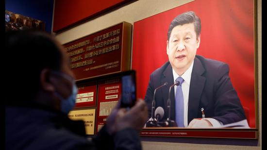 A man holds a mobile phone in front of an image of Chinese President Xi Jinping displayed at the Museum of the Communist Party of China, Beijing, China (REUTERS) A man holds a mobile phone in front of an image of Chinese President Xi Jinping displayed at the Museum of the Communist Party of China, Beijing, China (REUTERS)