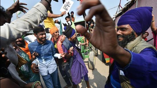 Farmers celebrate at Delhi’s Singhu border protest site after Prime Minister Narendra Modi announced that the three farm laws will be repealed. (PTI)