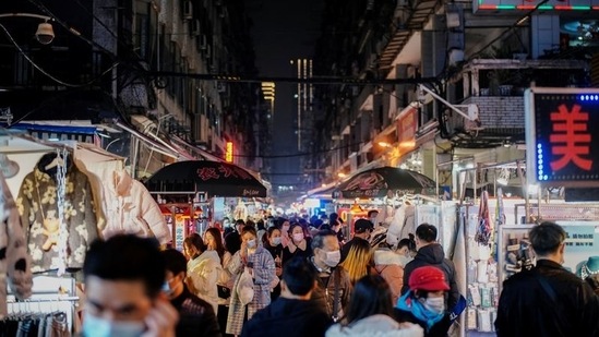 The origins of the Sars-CoV-2 virus, which causes Covid-19 remains a mystery, and a major source of tension between China and several western countries. In picture - People visit a street market almost a year after Covid in Wuhan, China.(Reuters)