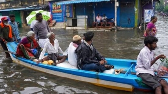File photo of people travelling by boat on a flooded stretch in Chennai.&nbsp;(AP)