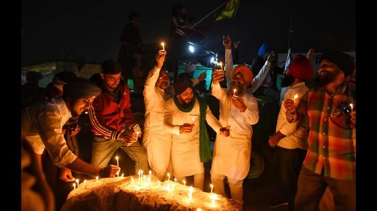 Farmers light candles to celebrate Guru Purab and the repeal of the three farm laws,at Singhu border in New Delhi on Friday. (Sanchit Khanna/H)