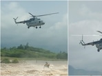The Mi-17 helicopter can be seen carrying out winching operation to rescue people stranded on the top of a JCB machine. The Mi-17 helicopter can be seen carrying out winching operation to rescue people stranded on the top of a JCB machine.