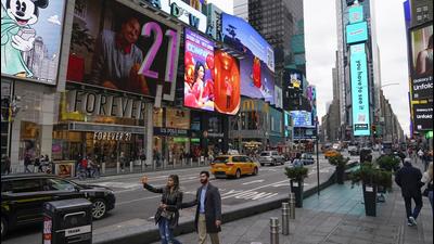 Pedestrians walk through Times Square while taking pictures on Monday, in New York. Even as visitors again crowd below the jumbo screens in New York’s Times Square, the souvenir shops, restaurants, hotels and entrepreneurs within the iconic US landmark are still reeling from a staggering pandemic. (AP) Pedestrians walk through Times Square while taking pictures on Monday, in New York. Even as visitors again crowd below the jumbo screens in New York’s Times Square, the souvenir shops, restaurants, hotels and entrepreneurs within the iconic US landmark are still reeling from a staggering pandemic. (AP)