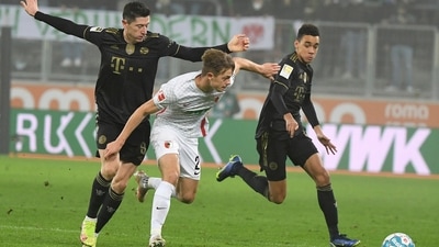 Augsburg's Robert Gumny, center, battles for the ball with Bayern's Robert Lewandowski, left, and Jamal Musiala during the German Bundesliga soccer match between FC Augsburg and Bayern Munich at the WWK Arena in Augsburg, Germany, Friday, Nov. 19, 2021 (AP) Augsburg's Robert Gumny, center, battles for the ball with Bayern's Robert Lewandowski, left, and Jamal Musiala during the German Bundesliga soccer match between FC Augsburg and Bayern Munich at the WWK Arena in Augsburg, Germany, Friday, Nov. 19, 2021 (AP)