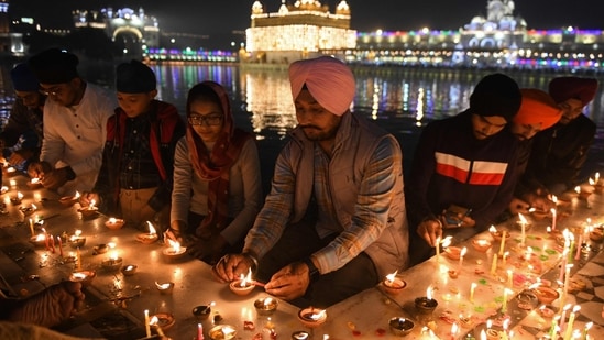 Sikh devotees light earthen lamps and candles at the illuminated Golden Temple in Amritsar. One of the devotees lighting oil lamps said to news agency ANI, "The 552nd Prakash Parv of Guru Nanak Dev is being celebrated with great reverence for our guru, who gave the world the message of 'Kirat Karo, 'Naam Japo', 'Vand Chako'. In various corners of the country, Sikhs are bowing down to their guru. I extend my wishes to everyone on this occasion."(AFP)