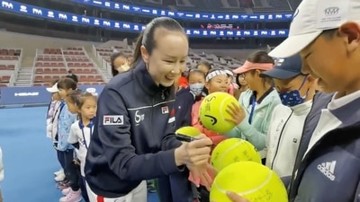 Chinese tennis player Peng Shuai signs large-sized tennis balls at the opening ceremony of Fila Kids Junior Tennis Challenger Final in Beijing, China November 21, 2021, in this screen grab obtained from a social media video.&nbsp; (TWITTER @QINGQINGPARIS via REUTERS)