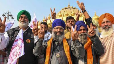 Farmers shout slogans to celebrate after Prime Minister Modi announced on Friday that three agricultural laws that sparked almost a year of huge protests across the country would be repealed. (AFP PHOTO.) Farmers shout slogans to celebrate after Prime Minister Modi announced on Friday that three agricultural laws that sparked almost a year of huge protests across the country would be repealed. (AFP PHOTO.)