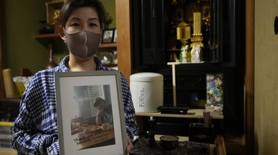 Kaori Takada poses with her brother's photo in front of her family altar at her home in Matsubara, south of Osaka on November 16, 2021. (AP Photo) Kaori Takada poses with her brother's photo in front of her family altar at her home in Matsubara, south of Osaka on November 16, 2021. (AP Photo)