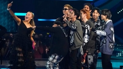 JoJo Siwa, left, took a selfie with BTS on stage as they accept the award for favorite pop duo or group at the American Music Awards. (Invision) JoJo Siwa, left, took a selfie with BTS on stage as they accept the award for favorite pop duo or group at the American Music Awards. (Invision)