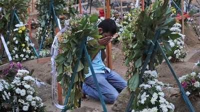 A Sri Lankan relative of a victim of Easter Sunday bomb blasts pays tribute at the burial site. (AP Photo) A Sri Lankan relative of a victim of Easter Sunday bomb blasts pays tribute at the burial site. (AP Photo)