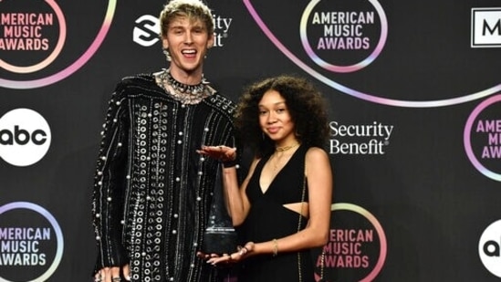 Machine Gun Kelly and his daughter Casie Colson Baker twin in black as they arrive at the American Music Awards 2021. Machine Gun Kelly took home the award for favourite rock artist.(Invision)