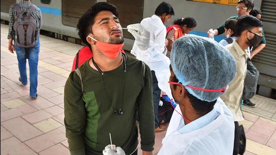 Mumbai, India -Nov 21, 2021: A BMC health worker collects swab samples for Covid-19 test of passengers arriving on outstation trains at Dadar Station, on 20 November 2021, in Mumbai, India, on Sunday, Nov 21, 2021. (Photo by Bhushan Koyande/ HT Photo) (HT PHoto) Mumbai, India -Nov 21, 2021: A BMC health worker collects swab samples for Covid-19 test of passengers arriving on outstation trains at Dadar Station, on 20 November 2021, in Mumbai, India, on Sunday, Nov 21, 2021. (Photo by Bhushan Koyande/ HT Photo) (HT PHoto)