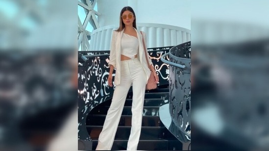 For the event, Mouni Roy opted for an all-white fit. She donned an asymmetrical crop top which she paired with straight-cut pants and a blazer.(Instagram/@imouniroy)
