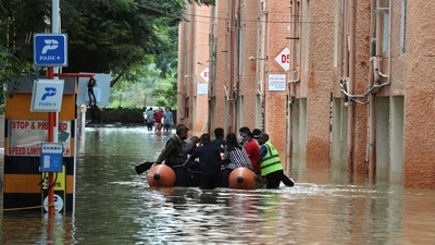 Rescue workers move stranded residents of an apartment in a boat after it was flooded due to heavy rains in Bengaluru. (AP)