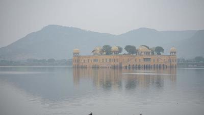 The Jal Mahal is seen shrouded in fog at Man Sagar Lake in Jaipur, Rajasthan. (PTI/File)