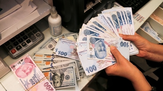 A money changer holds Turkish lira banknotes at a currency exchange office in Ankara(REUTERS) A money changer holds Turkish lira banknotes at a currency exchange office in Ankara(REUTERS)