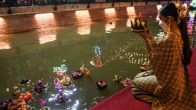 A woman prays with a krathong in her hand before releasing it in the canal on the occasion of Loy Krathong festival.&nbsp; (REUTERS)
