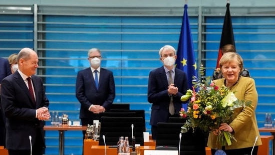 Acting German Chancellor Angela Merkel receives a bouquet from acting German Finance Minister Olaf Scholz prior to the weekly cabinet meeting at the Chancellery in Berlin, Germany.&nbsp;(REUTERS)