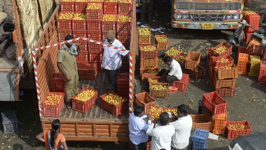 Traders and retail vendors negotiate the price of tomatoes at a vegetable wholesale market in Hyderabad on November 24.(AFP)