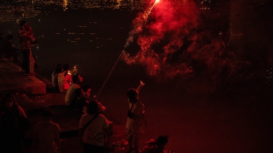 Visitors set off fireworks at the Ping River during the Loy Krathong festival in Chiang Mai, Thailand.(Bloomberg)