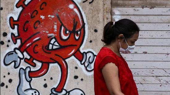 A woman walks past a Covid-awareness graffiti in Mumbai, India. (REUTERS/File) A woman walks past a Covid-awareness graffiti in Mumbai, India. (REUTERS/File)
