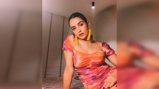 Drawstring dresses are the easy, comfy and stylish fashion trend that fashionistas love wearing. Actor Sanya Malhotra recently took to her Instagram handle to share a few stills of herself in a sunset-hued drawstring dress.(Instagram/@sanyamalhotra_)
