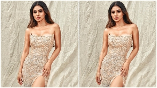 Mouni's strapless dress comes with a plunging neckline, flaunting her collarbones, and golden and blue ombre shaded sequins placed all over the outfit. The risqué side thigh-high slit flaunted her legs and added a sexy charm to Mouni's look.(Instagram/@imouniroy)