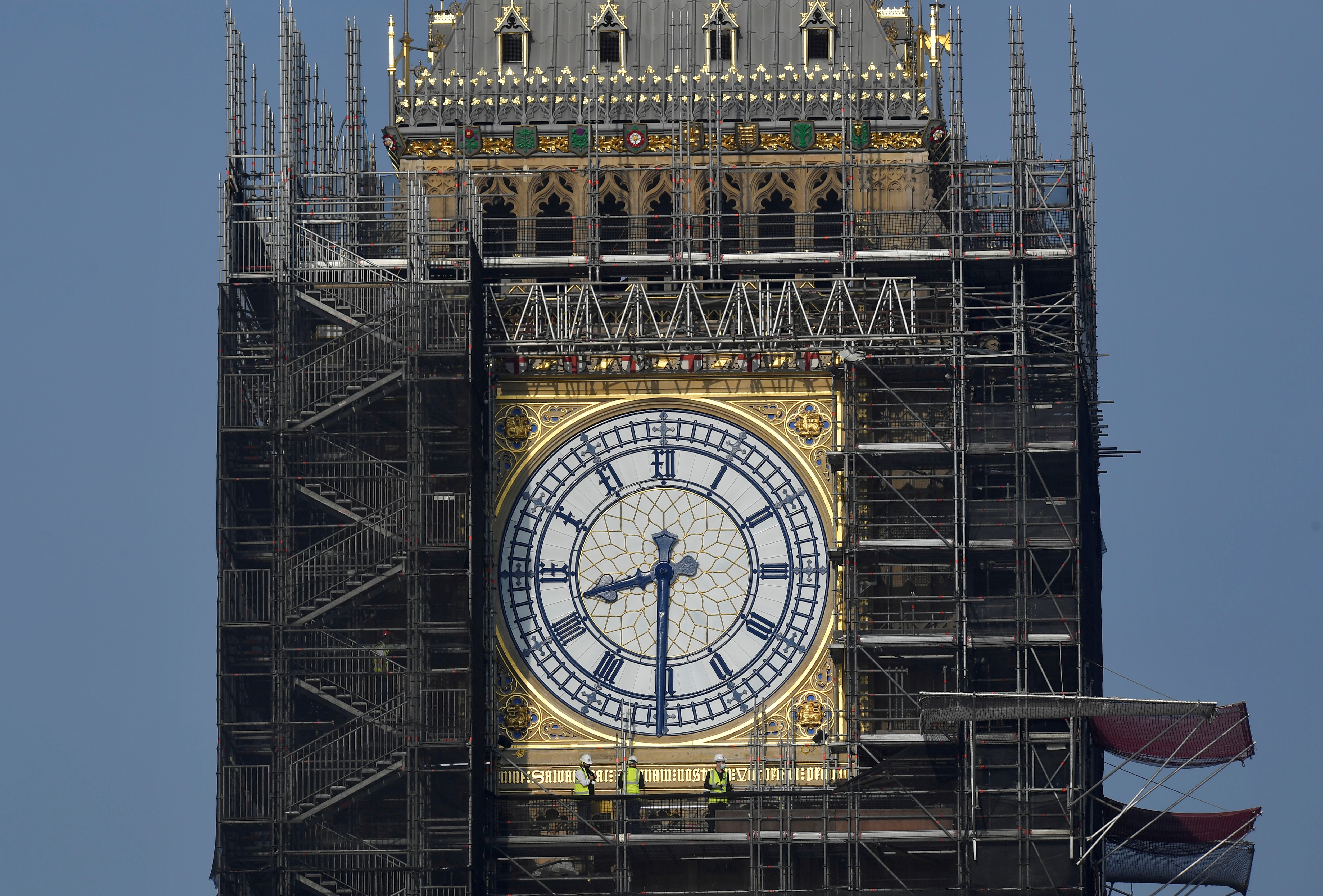 Workers stand on scaffolding underneath one of the clock faces on the Elizabeth Tower, more commonly known as Big Ben.&nbsp; (REUTERS)