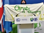 A protester holds a banner during the UN Climate Change Conference (COP26) in Glasgow, Scotland, on November 13. REUTERS A protester holds a banner during the UN Climate Change Conference (COP26) in Glasgow, Scotland, on November 13. REUTERS