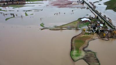 Houses and farms are seen cut off after record rainfall in Abbotsford, British Columbia, Canada on November 17, 2021. (AFP/File) Houses and farms are seen cut off after record rainfall in Abbotsford, British Columbia, Canada on November 17, 2021. (AFP/File)